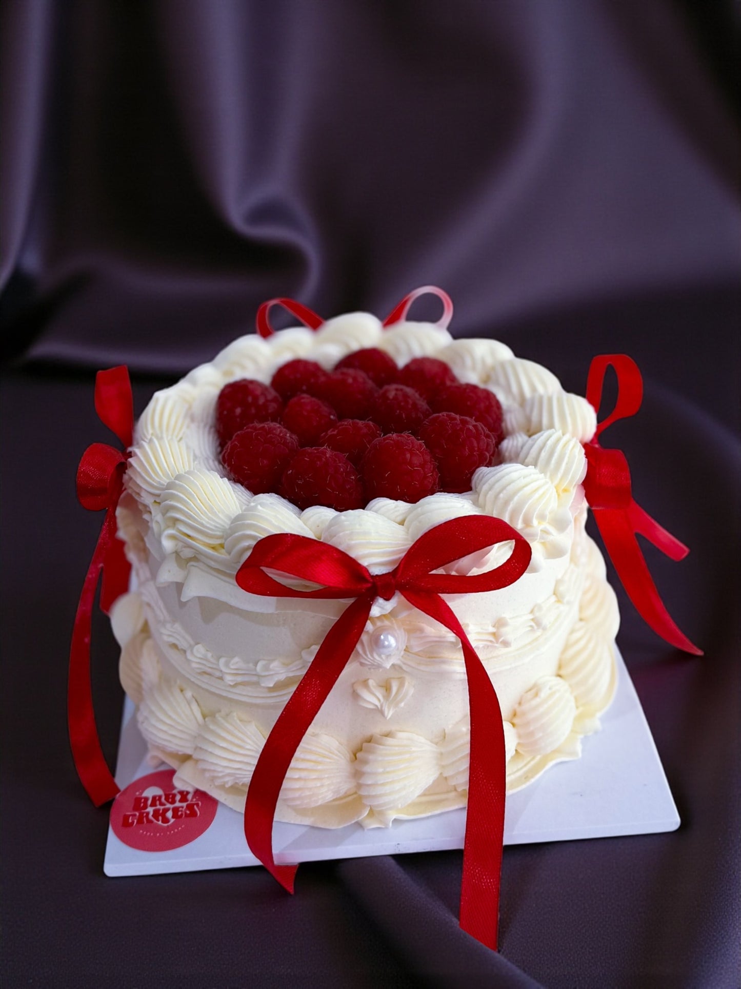 Valentineās Raspberry Ribbon Cake- a mini raspberry mini cake, finished with vintage piping and red ribbon bows. Serves 3-4 & made for Valentineās Day sharing.